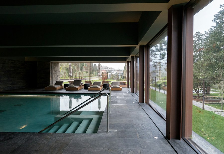Indoor pool with lounge chairs and windows