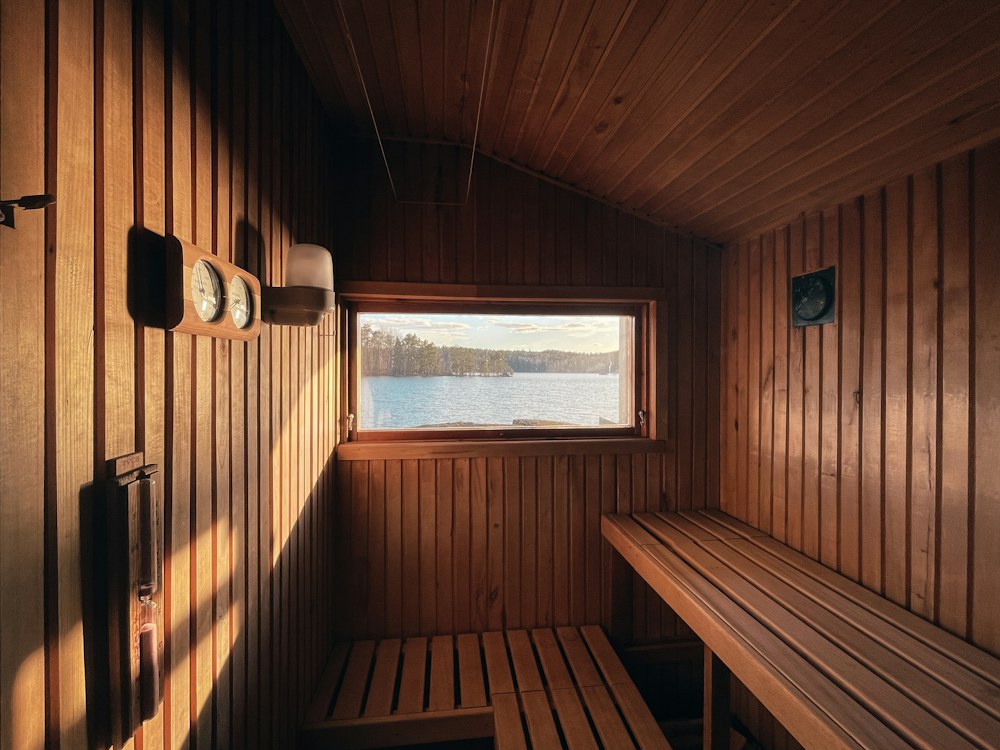 Wooden sauna cabin with a slatted bench, timer dials and a window
